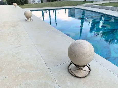 Smart outdoor living area with illuminated pool terrace and decorative stone sculptures